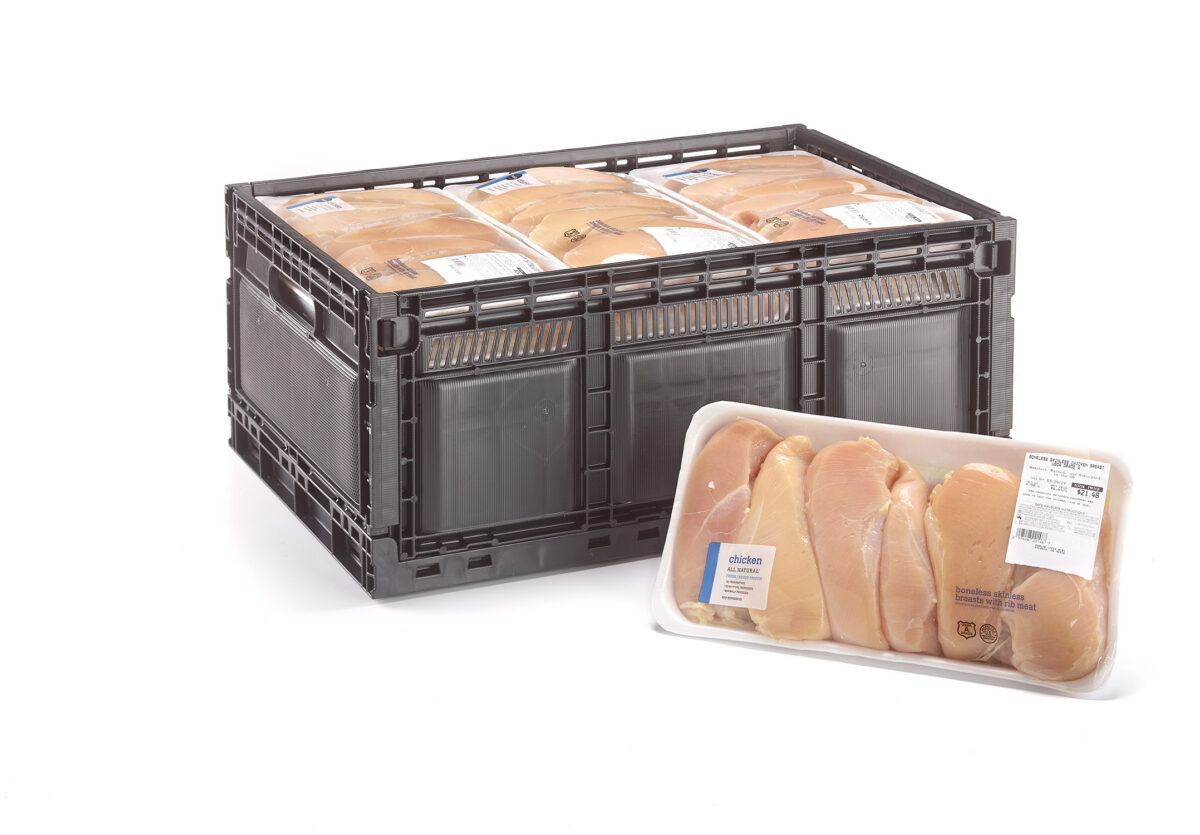 Packaged raw chicken breasts stacked in a black reusable plastic crate, ready for stock replenishment in a retail store.