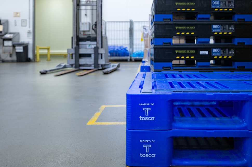 Stack of durable blue L1 plastic pallets, showcasing their strength, reusability, and efficient design for space-saving storage in supply chain operations