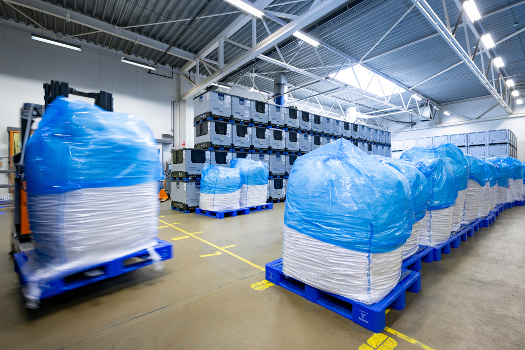 Tosca plastic pallets loaded with bulk dry food ingredients, positioned at a supplier facility and ready for transport, highlighting secure and efficient storage.