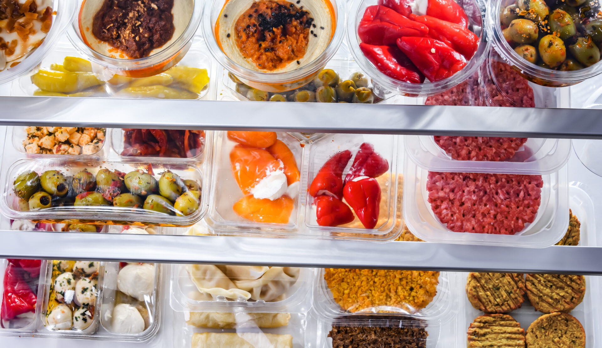 A display of variety of prepackaged food products in plastic boxes.