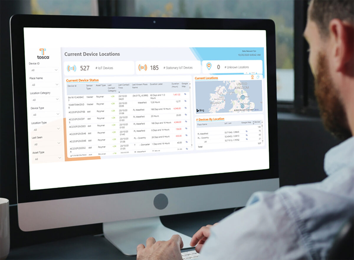 A Tosca employee sits in front of a computer, monitoring the current locations of IoT devices tracked by traceability sensors using the Tosca Hub customer web portal.