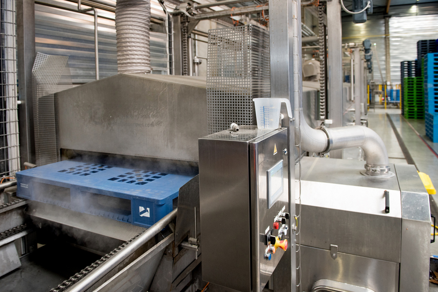 Tosca containers moving down a conveyor at a service centre as part of Tosca’s reusable asset sanitation process to ensure food safety.
