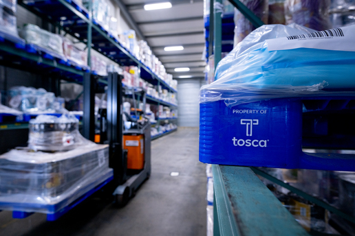Blue reusable plastic pallet is shown in an industrial warehouse environment.