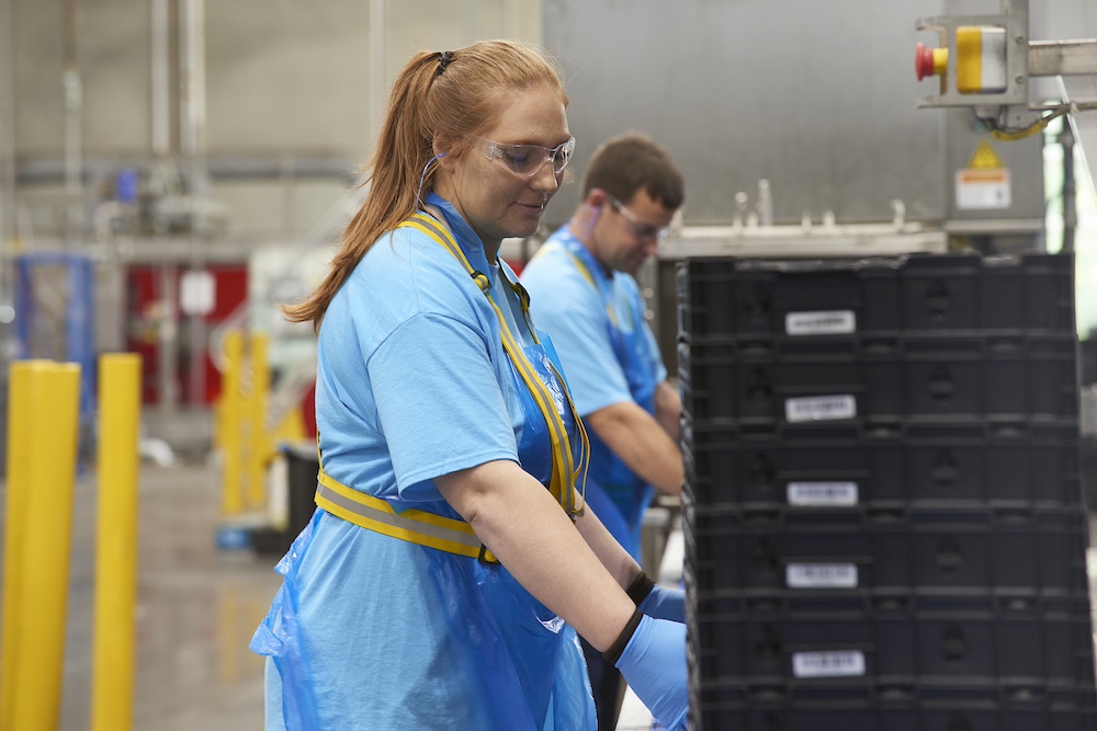 A Tosca service center worker stacks crates ready to be pooled