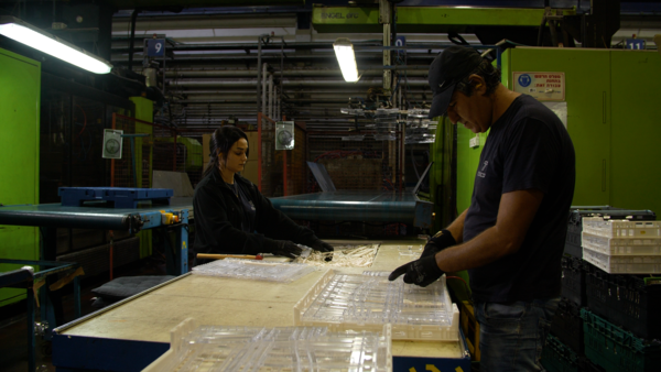 Production workers assembling custom plastic crates, a heavy-duty clear container designed by Tosca R&D experts for enhanced product visibility and an easy-to-collapse design for storage efficiency.