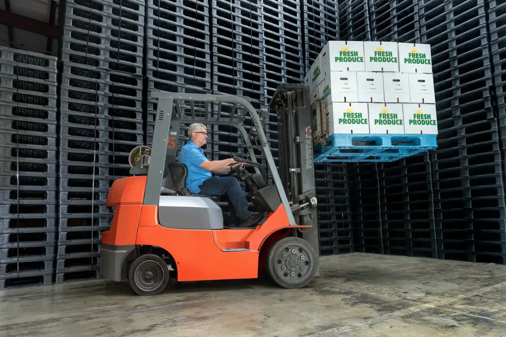 A forklift lifting stacks of Progrenic GMA+ pallets