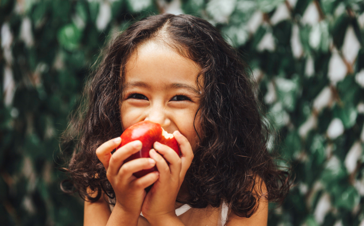 Girl eating an apple.